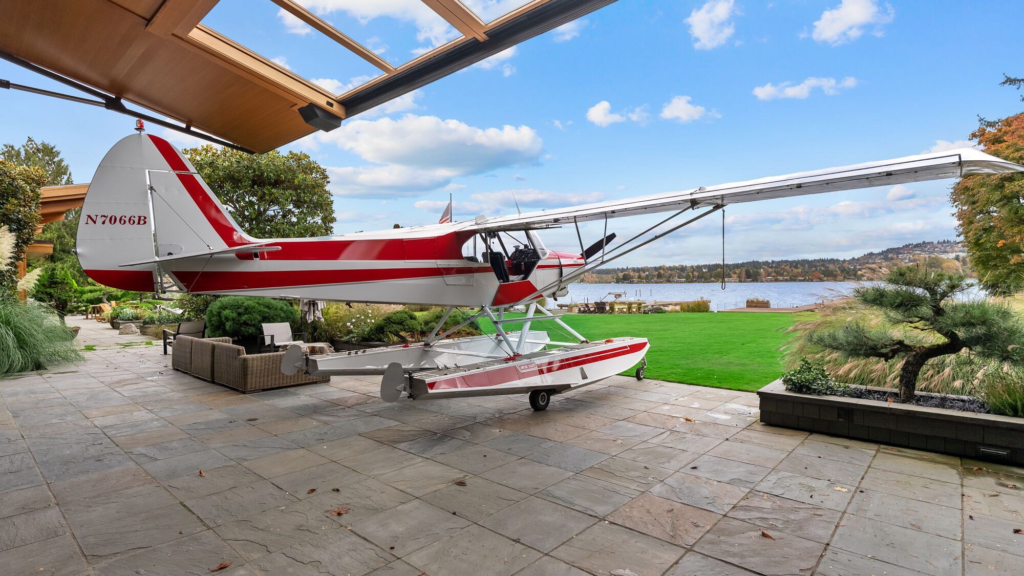Red and white Piper Super Cub on floats parked beside a lake